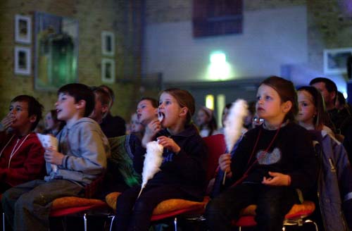 Kinder mit Zuckerwatte in der Hand und Spannung im Gesicht: Kino im Ballenlager.